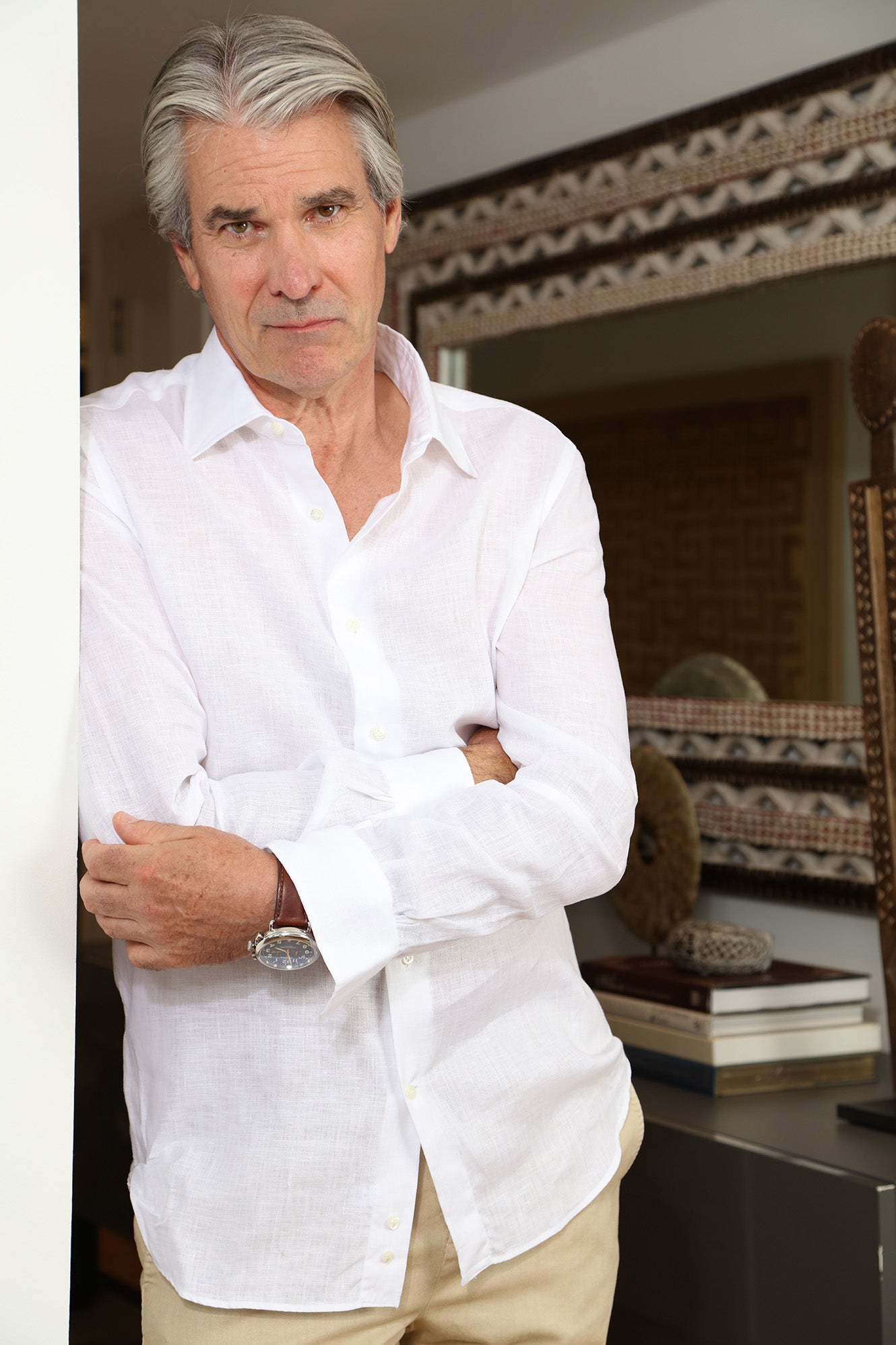 Man in White linen shirt with shoulder against wall